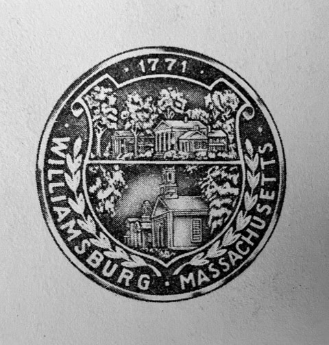 seal of williamsburg, massachusetts, featuring buildings, trees, the year 1771, and laurel branches, with the town's name around the border.