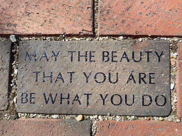 a brick on a sidewalk engraved with the words: "may the beauty that you are be what you do.