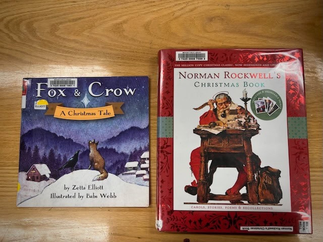 two christmas themed books lie on a wooden surface: "fox & crow: a christmas tale" and "norman rockwell's christmas book.