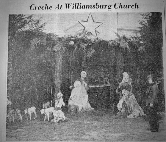 black and white photo showing a nativity scene display at williamsburg church, with figures of mary, joseph, baby jesus, animals, and a star above.
