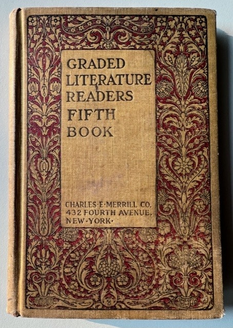a vintage hardcover book titled "graded literature readers fifth book" by charles e. merrill co., featuring ornate red floral patterns on a tan cover.
