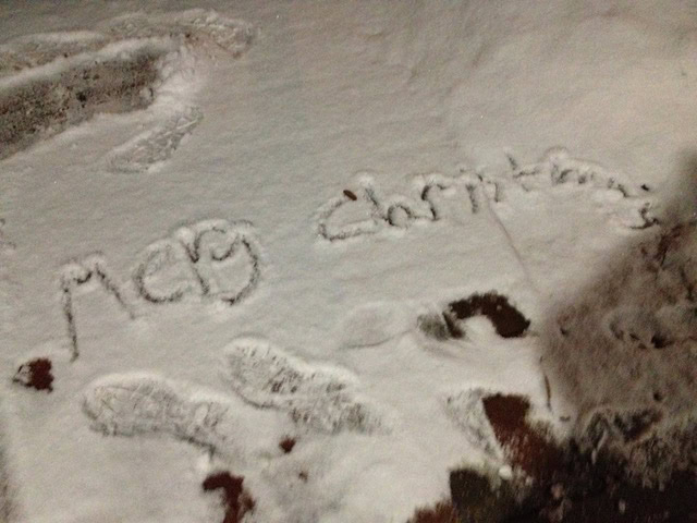 words 'mery christmas' are written in snow on the ground, with visible footprints surrounding the text.