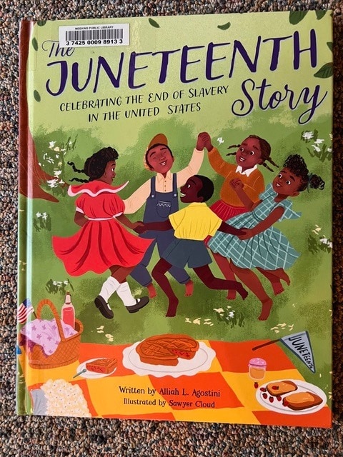 children dance in a circle on the cover of "the juneteenth story," a book about the end of slavery in the united states, with a picnic spread in the foreground.