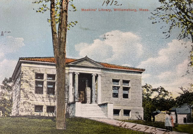 a postcard from 1912 shows the front entrance of meekins library in williamsburg, massachusetts, with two people standing on the lawn.
