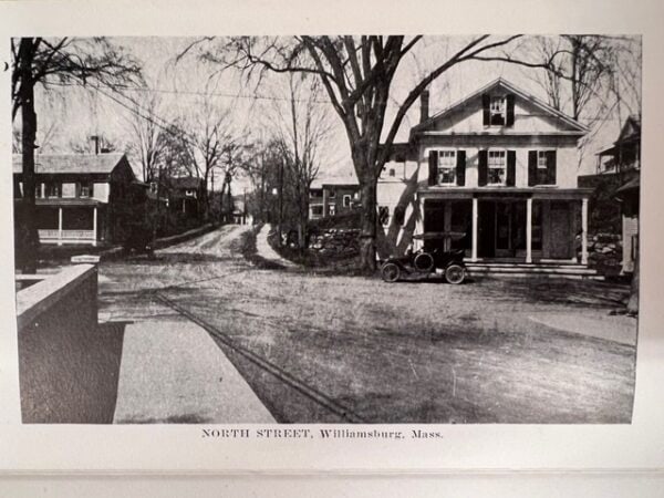 black and white photo of north street in williamsburg, massachusetts, showing early 20th century buildings, leafless trees, and a vintage car parked in front of a house.