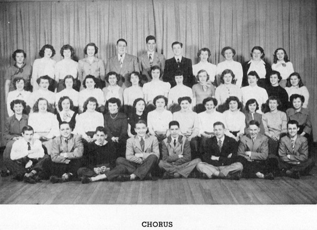 black and white group photo of a high school chorus, showing five rows of students posing in front of a curtain, labeled "chorus" at the bottom.