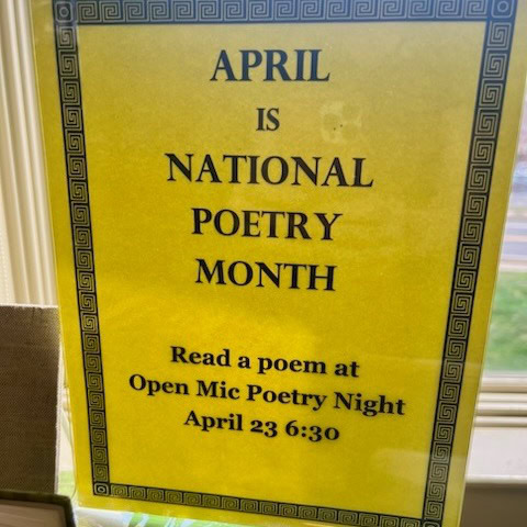 yellow sign announces april as national poetry month and invites people to read a poem at open mic poetry night on april 23 at 6:30.