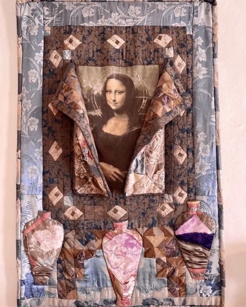 a quilted textile art piece features a fabric image of the mona lisa framed by patterned fabrics, with four colorful, vase like shapes sewn at the bottom.