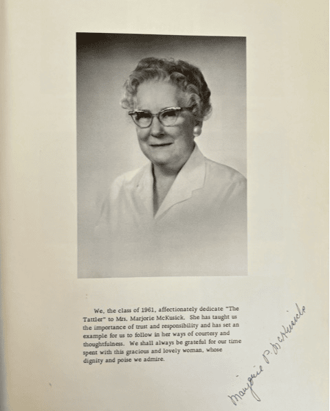 black and white portrait of an older woman with glasses and curly hair, accompanied by a dedication text and her handwritten signature on the right margin.