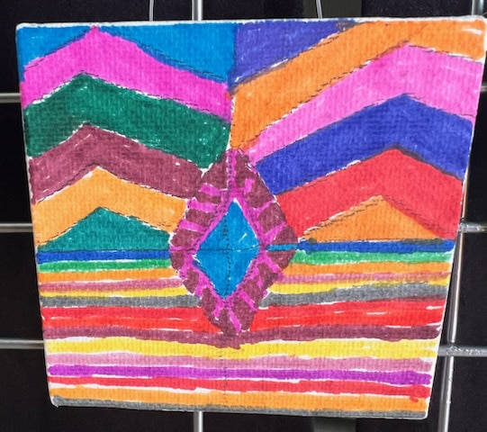 a square artwork features colorful zigzag and horizontal stripe patterns with a blue diamond shape in the center, drawn with markers on canvas.