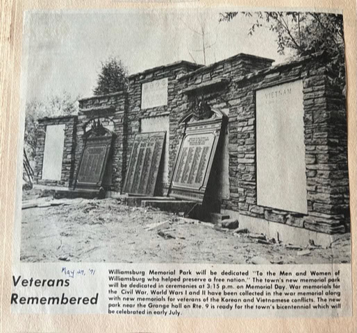 stone memorial wall at williamsburg memorial park displays plaques honoring veterans of several wars, with trees in the background. headline reads 