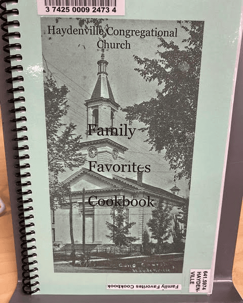 a spiral bound cookbook titled "family favorites cookbook" from haydenville congregational church, featuring a black and white photo of the church on the cover.